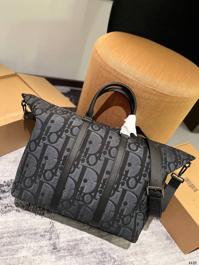 Dior Weekender 旅行袋 Weekender 40 手袋是二零二四春季男装系列新品，彰显经久不衰的高雅风格。采用米色和黑色超大oblique印花面料