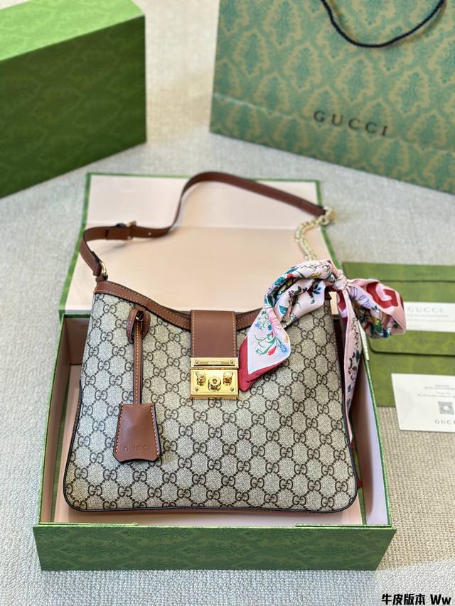 牛皮版本 Gucci Padlock Hobo 系列背包 这款肩背包采用GG SuPreme 帆布制作，亮眼缀饰挂锁 式锁扣，致意品牌由行李箱工作室发展至今的悠