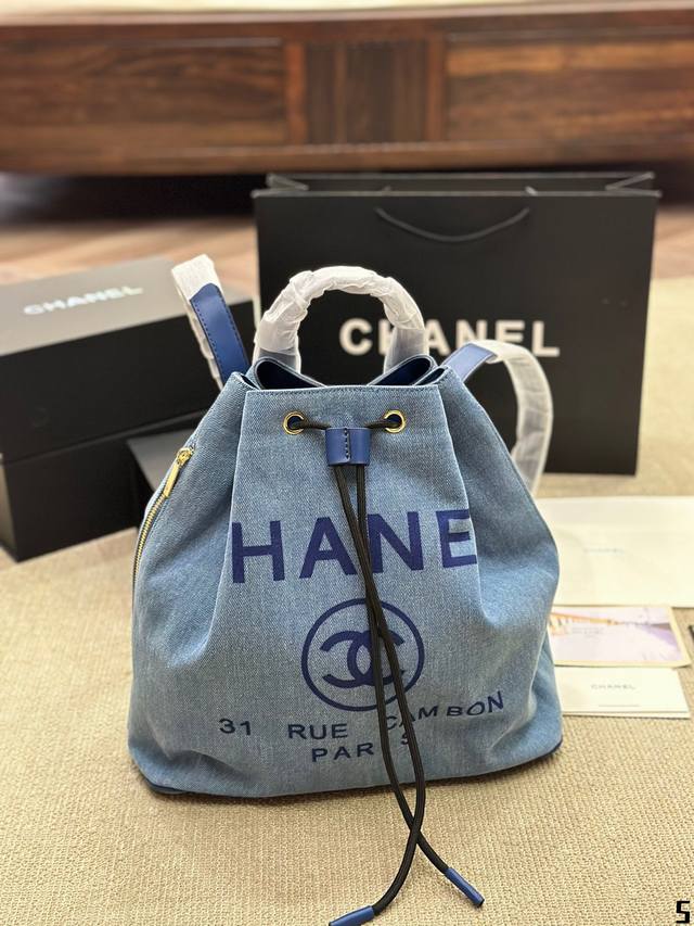 Chanel 牛仔丹宁 双肩包chanel抽绳双肩包无疑是夏天出行必备包包之一。牛仔丹宁的材质随性又耐造，随意搭配时尚感十足，包身自带做1旧感，包口抽绳的设计拿