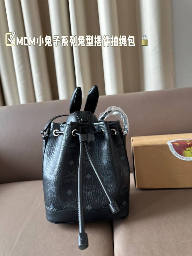 Mcm小兔子系列兔型摆件抽绳包 Visetos印花为经典款式注入一点别致的味道 小兔子摆件可以拆卸放在内部口袋里 或使用弹簧扣附在斜挎背带上 可调节长肩带 顶部