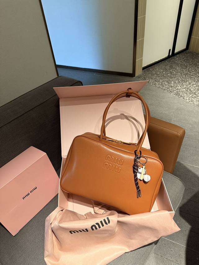 Size：35*22Cm Miumiu保龄球 公文包 采用小牛皮配帆布 皮质光滑细腻柔软， 棉质缎面衬里。 背起来都很nice 哦 出场就是miumiu小公主！