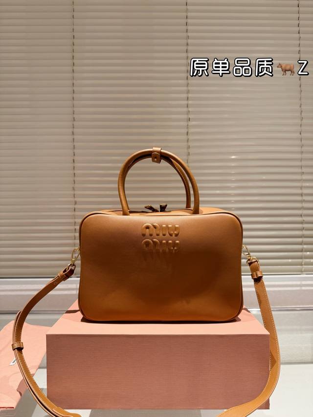 复刻版 纯牛皮 Miumiu-保龄球 斜挎包 新款手袋是对经典 Bauletto 造型的重新诠释，其简洁利落的剪裁彰显出该系列背后的功能性和实用主义概念。尘埃色